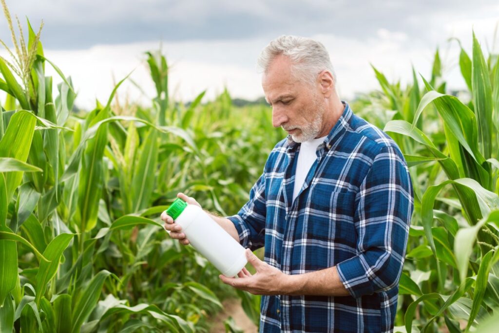 agricoltore controlla prodotto chimico per rimozione delle malerbe