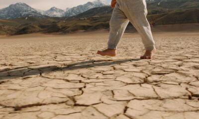siccità, cambiamento climatico, bambino cammina a piedi nudi su terreno secco
