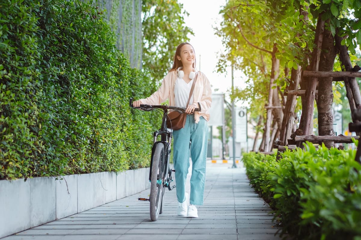 ragazza che cammina con la bicicletta per mano