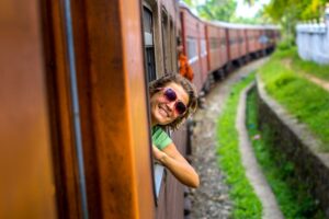 ragazza sorridente che si sporge dal vagone di un treno