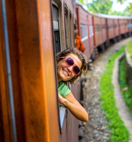 ragazza sorridente che si sporge dal vagone di un treno