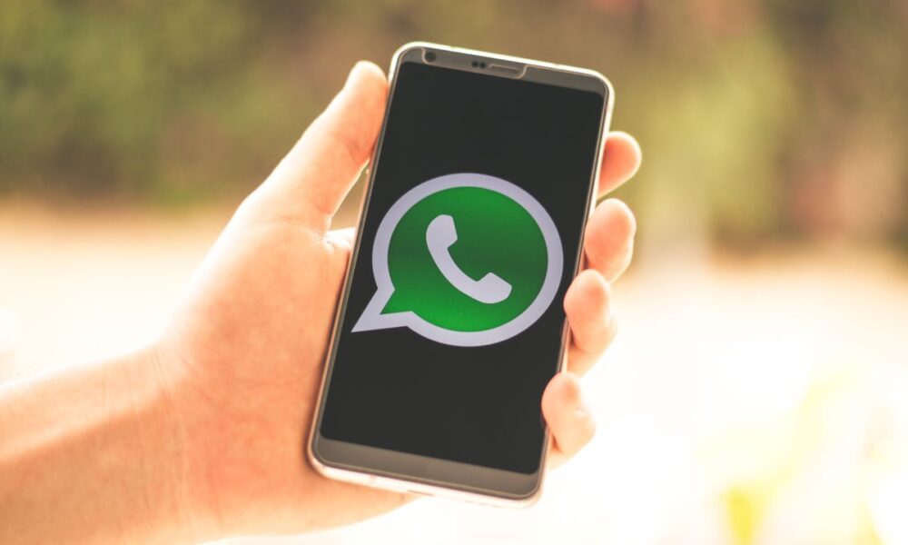 Mano che tiene in mano uno smartphone con aperto whatsapp