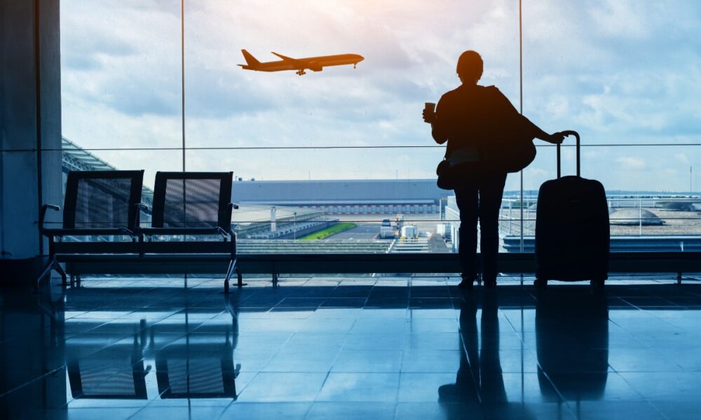 Donna con valigia in aeroporto in attesa del proprio volo