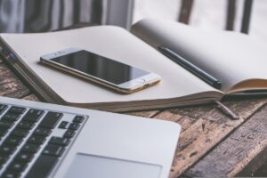 Scrivania ordinata con computer, telefono e agenda.
