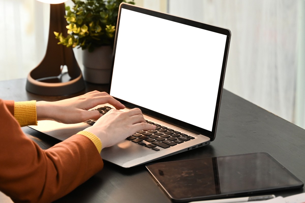 Ragazza al lavoro su computer e tablet.