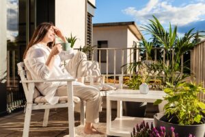 Ragazza si rilassa sul balcone arredato, in una calda giornata estiva
