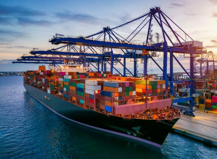 Nave cargo carica di container attraccata in un porto commerciale.