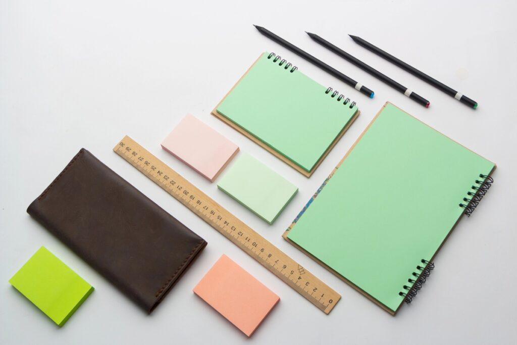 Set di gadget di cancelleria con agende, matite e post-it colorati.