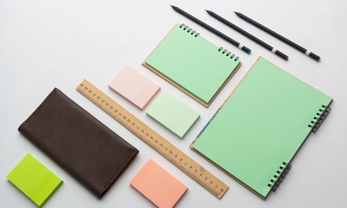 Set di gadget di cancelleria con agende, matite e post-it colorati.