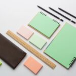 Set di gadget di cancelleria con agende, matite e post-it colorati.