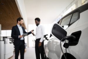 Dettagli di vendita/noleggio: trattativa per un'auto elettrica tra venditore e cliente.