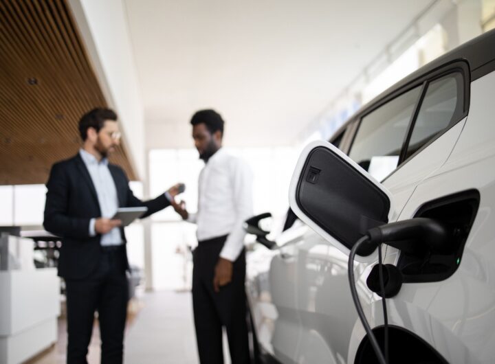 Dettagli di vendita/noleggio: trattativa per un'auto elettrica tra venditore e cliente.