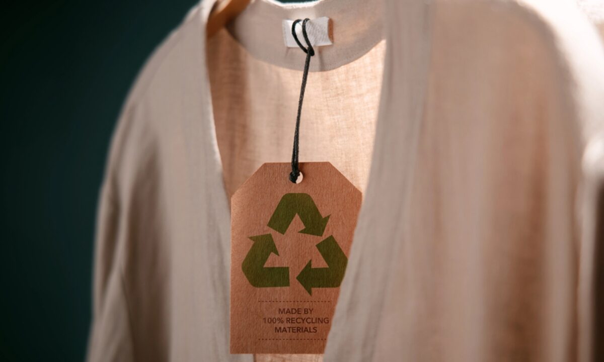 Camicia eco-friendly: dettaglio del cartellino che certifica il 100% di materiale riciclato.